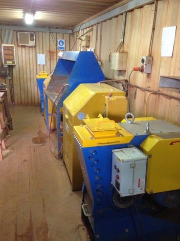 Two pulverisers positioned on either side of a workbench, with two crushers on either side of the pulverisers.